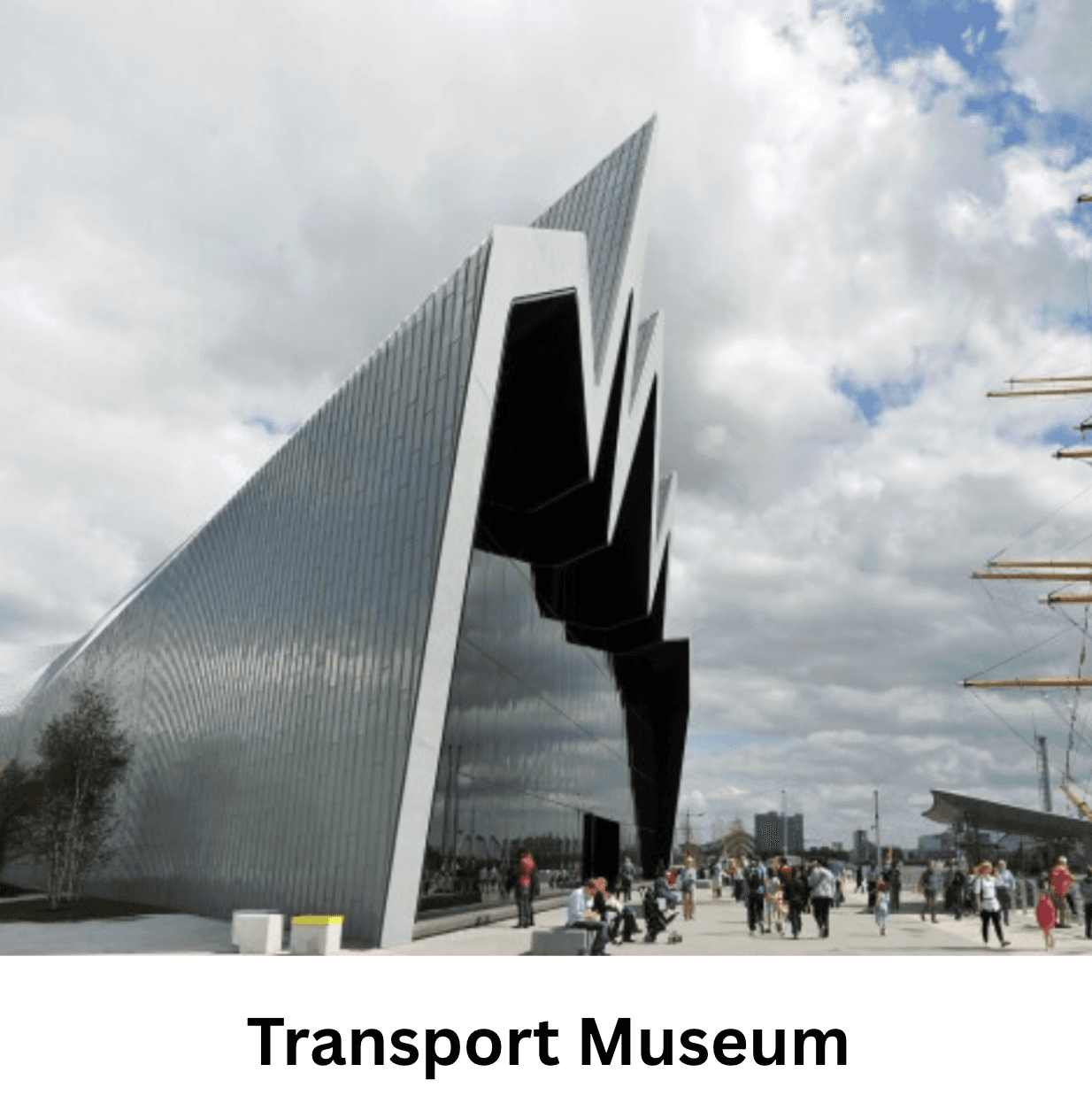 Modern transport museum with a sharp zig-zag roof and glass facade under cloudy skies.
